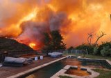 Wildfire tears through affluent suburbs of north Los Angeles